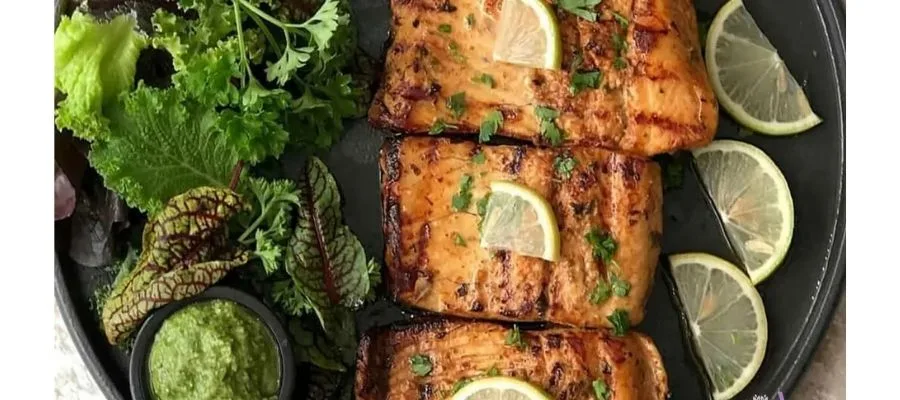 چیدن فیله سالمون و سبزیجات در سینی فر